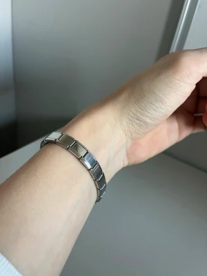 Silverfärgat länkarmsband i stål - Snyggt armband i silverfärgat rostfritt stål med klassisk länkkonstruktion. Armbandet har en stilren och minimalistisk design med rektangulära länkar som ger en modern känsla. Perfekt för dig som gillar enkel men trendig stil.