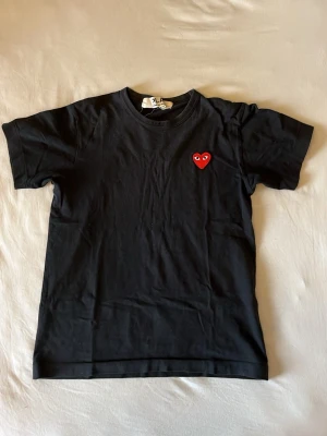 T-shirt Comme des Garçons - Svart t-shirt från Comme des Garçons storlek s. Inköpt på NK i Stockholm och är i jättefint skick. Funkar unisex. Som de flesta vet så är CDG liten i storlek så denna passar även xs 