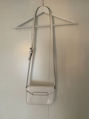 Stilren väska  - Säljer en vit väska som passa till alla tillfällen. Köpt från Lindex. Efterlinar ormskin som material på väskan. Superfin och priset är förhandlingsbart!!