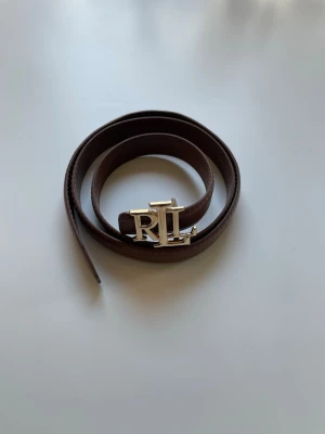 Brunt skärp från Ralph Lauren - Säljer ett skärp från Ralph Lauren, skärpet är 110cm lång med 10 hål för att kunna ändra storlek. Säljer den för 150kr skickar paket samma dag eller dagen efter ☺️