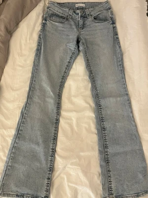 Ljusblå bootcut jeans från Lee - Säljer ett par ljusblå bootcut jeans från gina tricot med klassisk femficksdesign och dragkedjegylf. Jeansen har en snygg tvättad look och är tillverkade i mjuk denim. Perfekta för dig som gillar retrovibbar och avslappnad stil.