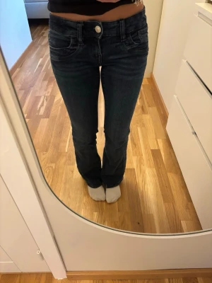 Mörkblå bootcut jeans - Säljer ett par mörkblå bootcut jeans med klassisk femficksdesign och låg midja. Jeansen har snygga sömmar och en silverfärgad knapp framtill. Materialet är stretchigt denim för extra komfort. Använd fåtal gånger, säljer då dem är lite korta för mig, jag är 156cm.🦋💙