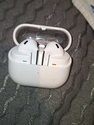 Vita trådlösa in-ear hörlurar - Säljer ett par vita trådlösa in-ear hörlurar med laddningsetui. Hörlurarna har en stilren design med svarta detaljer och indikatorlampor på etuiet. Perfekta för musik, poddar och samtal på språng.