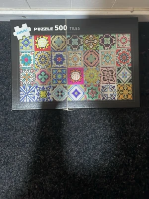 Färgglatt pussel med 500 bitar - Säljer ett pussel från Ravensburger med 500 bitar. Motivet består av olika färgglada och mönstrade kakelplattor i geometriska och blommiga former. Perfekt för dig som gillar utmanande pussel och snygga designmönster.