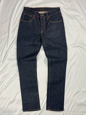 Nudie Jeans Grim Tim – Org. Dry Navy – Strl W32/L32 - Färg: Mörkblå raw/dry denim | Modell: Grim Tim slim straight | Storlek: W32/L32 | Skick: 10/10 | Stretch | Hör av dig vid frågor!