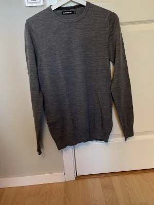 Grå rundhalsad tröja J.Lindeberg - Stilren grå tröja från J.Lindeberg med rund halsringning. Tillverkad i merinoull. Storleken är M, men skulle säga att den sitter bättre som S. Hör gärna av dig vid frågor😁
