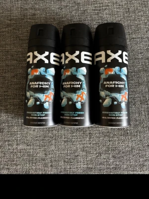 Axe Anarchy For Him Deospray 3-pack - Tre svarta deosprayer från Axe, modellen Anarchy For Him. Flaskorna har blå och vita detaljer samt text i vitt och blått. Designen är modern med grafiska element och spraylock. Passar dig som vill ha en fräsch och maskulin doft.