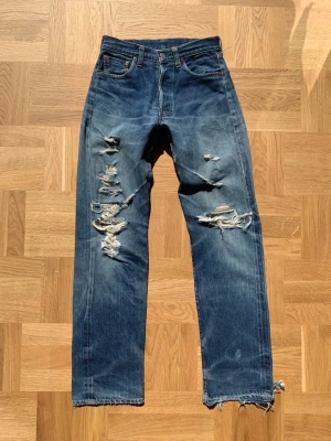 Levi’s 501xx Big E ”555 button” - Extremt sällsynta Levi’s 501xx selvedge jeans som är över 30 år gamla. Jeansen har fabrikskod ”555” som indikerar på fabriken i Valencia street i San Fransisco som stängdes ner i början av 2000-talet. Revor och mindre defekter förekommer men med tanken på åldern så är det naturligt, en större lagning har även gjorts på bakdelen proffesionellt. Storlek w29 men utgå från angivna mått:  Ytterben: 107 Innerben: 81 Midja:37 Benöppning:21  Kom gärna med bud! /william
