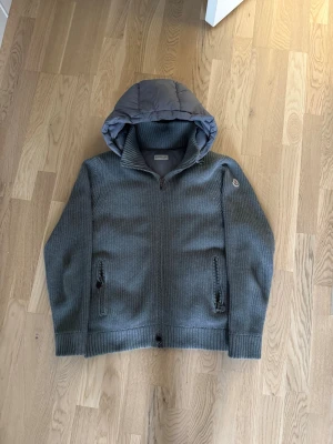 Moncler cardigan - Säljer en unik grå moncler cardigan som är väldigt stilren och modern. En väldigt trendig cardigan jacka som är perfekt nu när det börjar bli lite varmare ute.