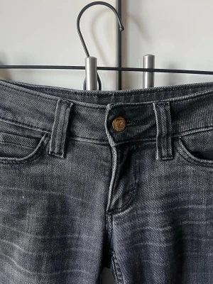 Cheap Monday svarta skinny jeans - Säljer ett par svarta skinny jeans från Cheap Monday med klassisk femficksdesign och ikonisk dödskallepatch baktill. Jeansen är i stretchigt denimtyg. Jeans från weekday de är lite uppsydda och sedan medsprättade så de är kortare än de vanliga strl 24/30