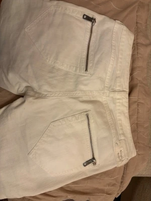 Coola unika vita lågmidjade jeans  - Extremt lågmidjade (2000-tals lågmidja). Super skinny jeans med coola silver detaljer. Kritvita, super fina, säljer pga försmå. Unika Diseljeans. Passar som W22 L34. Dom är små i storlek. Material bomull och estinal. 