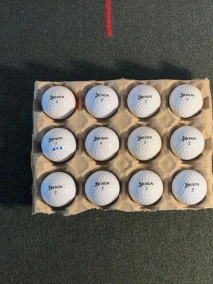  Srixon golfbollar  - Säljer ett set med 12 vita golfbollar från Srixon. Bollarna har klassisk rund form och är tillverkade i slitstarkt material. Perfekt för dig som vill fylla på golfbagen inför säsongen. Levereras i praktisk kartonghållare.