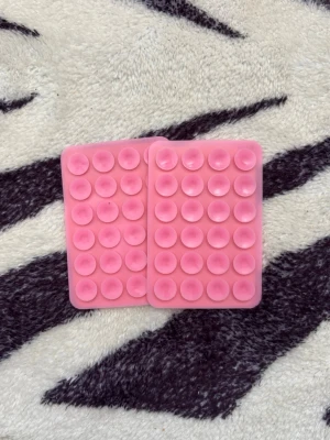 Två rosa pop it octopus mobilgrepp  - Säljer två rektangulära pop it-leksaker i rosa silikon. Varje platta har flera runda bubblor som kan tryckas in och ut, perfekt för stresslindring eller som fidget-toy. Smidiga att ta med i väskan eller fickan.