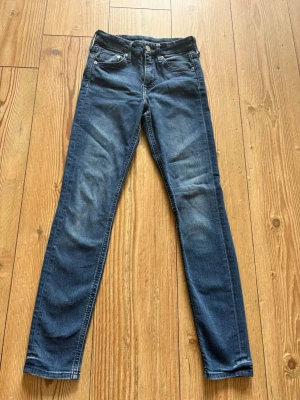Mörkblå skinny jeans med slitningar - Snygga mörkblå skinny jeans med lätt slitna detaljer på framsidan och klassisk femficksmodell. Jeansen har normal midja och smal passform hela vägen ner. Perfekta till en avslappnad och trendig stil.xs storlek i bra skick från h&m
