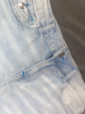 Ljusblå True Religion jeans - Säljer ett par ljusblå jeans från True Religion som är köpta i Berlin för 1700 🤍 med ikoniska sömmar och silverfärgade knappar. Jeansen har fickor med lock och tydliga blå kontrastsömmar. Materialet är klassisk denim i bomull med en tvättad look.