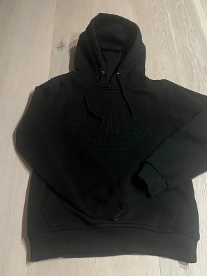Moncler hoodie - Säljer nu en svart moncler hoodie i ett ganska bra skick står storlek small men skulle säga sitter som barn 12-13 hör av dig om intresserad 