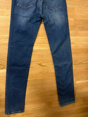 Blåa dressmann jeans  - Snygga blå slim fit jeans klassisk femficksdesign. Jeansen har normal midja och smal passform hela vägen ner. Tillverkade i denim med stretch för extra komfort. Perfekta för en trendig och avslappnad look.  W:32 L:34
