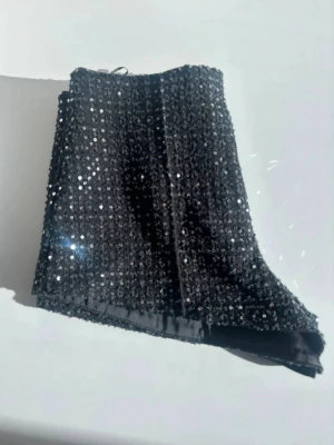 Svarta glittriga shorts med paljetter - Supersnygga svarta shorts täckta med glittrande paljetter. Tyvärr lite stora för mig nu. Perfekta för dig som vill ha något extra till din outfit.