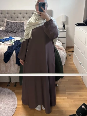 Rosa abaya med lång ärm - Snygg  rosa abaya med lös passform och stängda ärmar. Klänningen har en enkel och stilren design utan mönster, perfekt för dig som gillar minimalistiskt mode. Tillverkad i ett mjukt och lätt material som faller fint. Från luude collection