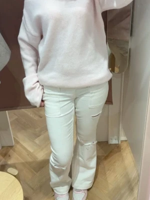 Vita straight jeans med fickor - Snygga vita jeans med raka ben och coola slitningar på knäna. Byxorna har stora fickor framtill och en avslappnad passform. Perfekta för dig som gillar en clean och trendig stil.