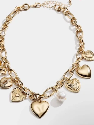 Guldigt halsband med hjärtan och pärlor  - Snyggt halsband i guldfärgad metall med flera hjärtformade hängen och detaljer. Kedjan är grov och har dekorativa berlocker, inklusive en vit pärla och olika hjärtan med mönster. Perfekt accessoar för att lyfta din outfit.