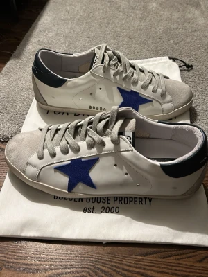 Golden Goose vita sneakers med blå stjärna - Golden Goose skor i storlek 43. Säljer då de inte passar:(. Fint skick och knappt använda.                       Pris kan diskuteras.