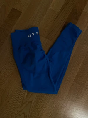 Blå seamless tights från GTECH - Snygga blå seamless tights från GTECH med hög midja och ribbad linning. Tillverkade i stretchigt funktionsmaterial som sitter skönt och formar sig efter. Perfekta för träning eller gymmet, med diskret logga framtill i vitt.