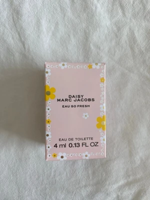 Daisy Eau So Fresh Marc Jacobs 4 ml - Söt miniflaska av Daisy Eau So Fresh från Marc Jacobs. Parfymen kommer i en genomskinlig glasflaska med ett ljusrosa blomformat lock och guldknopp. Förpackningen är ljusrosa med vita och gula blommor. Perfekt att ha med i väskan. Helt ny och aldrig använd!!