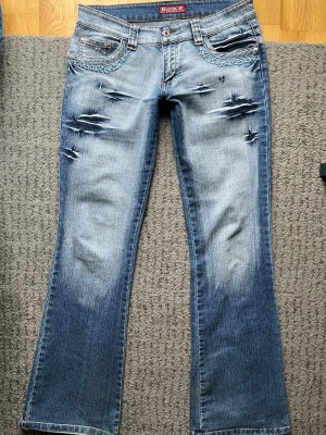 Blå bootcut jeans med brodyr - Snygga blå bootcut jeans. Använda fåtal gånger av mig, köpta på vinted innan de. Lite slitna nere vid hälarna (se sista bilden). Hittar inte vart storleken står men skulle säga S/M. Mått finns på bilderna. 