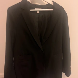 Svart blazer från H&M - Svart blazer från H&M med två fickor framtill. Storlek M, i använt men bra skick!