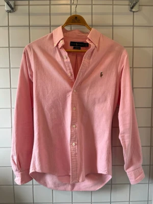 Ralph Lauren skjorta  - Nu säljer jag min rosa ralph lauren skjorta! Den är i storlek S och är slim fit. Användes under förra sommaren men är som nyskick. Hör av dig för fler frågor och bilder!!!