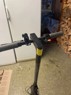 Svart elscooter med laddare - Säljer en svart elscooter med robust ram och greppvänliga handtag. Scootern har en enkel display, ringklocka och laddas via medföljande laddare. Perfekt för smidig transport i stan. Materialet är mestadels metall och plast. Räckvidd: ungefär 20km, 20km/h, lite använt. 1800kr med laddare 2000. Priset kan dock diskuteras mycket.
