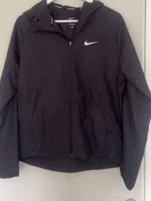 Svart vindjacka från Nike - Säljer min svarta jacka från Nike då jag köpt en annan i samma modell, storlek S, köpt från Nike hemsida för ca 1100. 