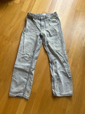 grå jeans - Säljer ett par grå jeans med rak passform. Jeansen har knapp- och dragkedjegylf samt bälteshällor i midjan. Perfekta om du vill ha ett par snygga jeans