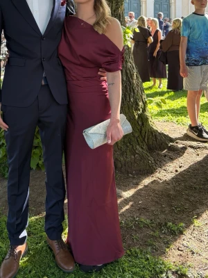 Vinröd oneshoulder långklänning - Säljer denna fina balklänning ifrån Gina. Använd en gång och i nytt skick 🥰