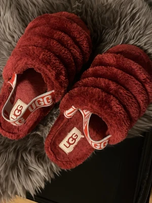 Röda fluffiga tofflor  - Säljer ett par röda, supermjuka och fluffiga tofflor .Perfekta för att mysa runt hemma i och riktigt sköna att ha på sig.