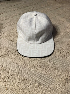 Fendi keps - Snygg vit keps från Fendi med det klassiska FF-monogrammönstret. Kom pm vid funderingar!
