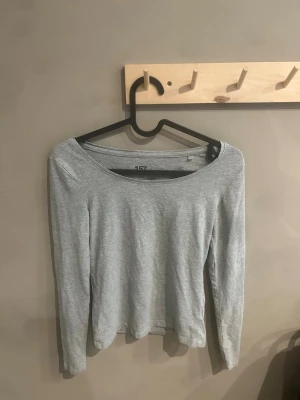 Ljusgrå långärmad topp från 157 - En enkel och stilren ljusgrå långärmad topp från 157. Tillverkad i mjuk bomullsblandning med rund halsringning och normal passform. Perfekt basplagg att matcha med allt i garderoben.