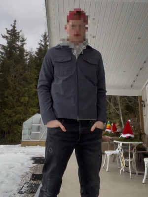 Fred Perry Mörkblå vindjacka - Snygg mörkblå vindjacka med dragkedja framtill och två bröstfickor med lock. Jackan har en enkel, stilren design och är långärmad. Perfekt för dig som gillar en clean look och vill ha något lätt att slänga på sig. Original pris 2500kr 