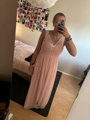 Ljusrosa bal kläning  - En jätte fin ljusrosa balklänning med v-ringning och pärldetaljer längs urringningen. Den är bara använd en gång🩷skriv om du har andra frågor 
