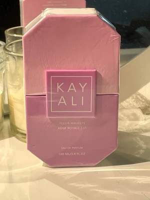 Kayali Fleur Majesty Rose Royale parfym - Kayali Fleur Majesty Rose Royale är en Eau de Parfum i en lyxig, rosa glasflaska med fasettslipad kork. Doften kommer i en elegant rosa förpackning och flaskan rymmer 100 ml. Designen är modern och feminin, perfekt för dig som gillar exklusiva parfymer med rosdoft.