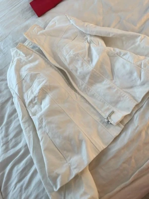 Vit jeansjacka från Fuchs Schmitt - Snygg vit jeansjacka från Fuchs Schmitt med dragkedja framtill och raka sömmar. Jackan har två bröstfickor och en stilren, minimalistisk design som passar perfekt till många olika outfits. Materialet är klassiskt jeans och jackan har en modern passform.