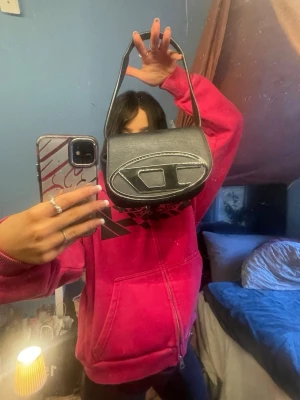 Diesel väska  - Diesel väska bara använd några gånger. Kommer med ett långt axel band ochså. För liten väska för mig så kommer ej till användning.