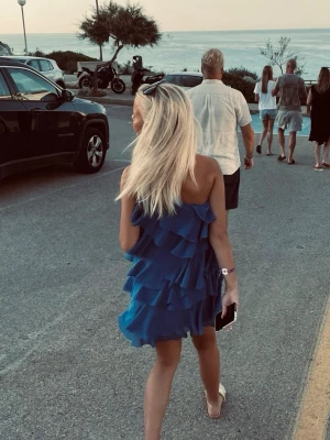 Blå volangklänning med one shoulder - Snygg blå kortklänning med flera volanglager och one shoulder-design. Klänningen har en luftig och somrig känsla, perfekt för varma dagar. Tillverkad i ett lätt tyg som ger ett fint fall och rörelse 💙💙