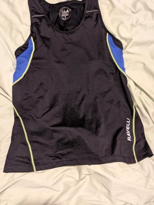 Svart löparlinne från Ravelli - Nytt träningslinne från Ravelli Tillverkat i funktionsmaterial som andas, inbyggd bh. Endast provat, stl xl men liten i stl därför säljer jag linnet.