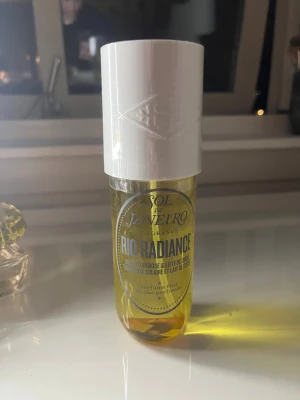 Sol de Janeiro Rio Radiance parfym - Sol de Janeiro Rio Radiance är en parfymmist med en fräsch och solig doft. Flaskan är cylindrisk med transparent gul plast och ett stort vitt plastlock. Perfekt för dig som gillar tropiska och mjuka dofter. Helt oanvänd