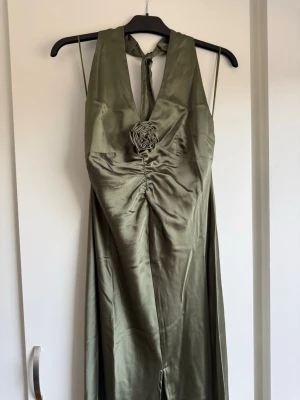 Maxiklänning - Snygg khaki maxiklänning med halterneck och knyt i nacken. Helt ny med prislapp, från Gina Tricot.