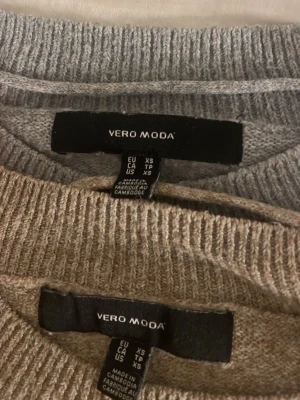 Beige fluffig tröja från H&M - Två mysiga stickade tröjor från vero moda, med fluffig textur och rund halsringning. Tröjorna har ribbade muddar vid ärmslut och nederkant, perfekt för lager-på-lager och chill dagar.