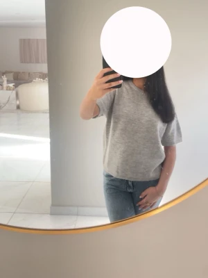 Grå t-shirt i bomull - Enkel och stilren grå t-shirt med korta ärmar och rund halsringning. Tillverkad i mjuk bomull, perfekt för en avslappnad look. Passformen är normal och toppen är lätt att matcha med olika outfits. Använd 2 gånger.