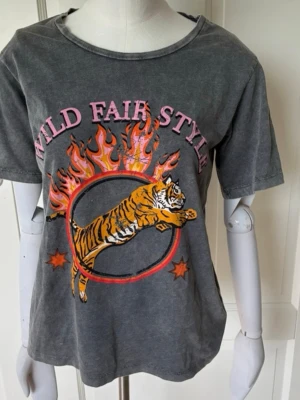 Grå t-shirt med tryck - Snygg grå t-shirt med tryck. T-shirten har rund hals och korta ärmar. Säljer pga att den inte används och storleken kan upplevas som xs/s/m💓